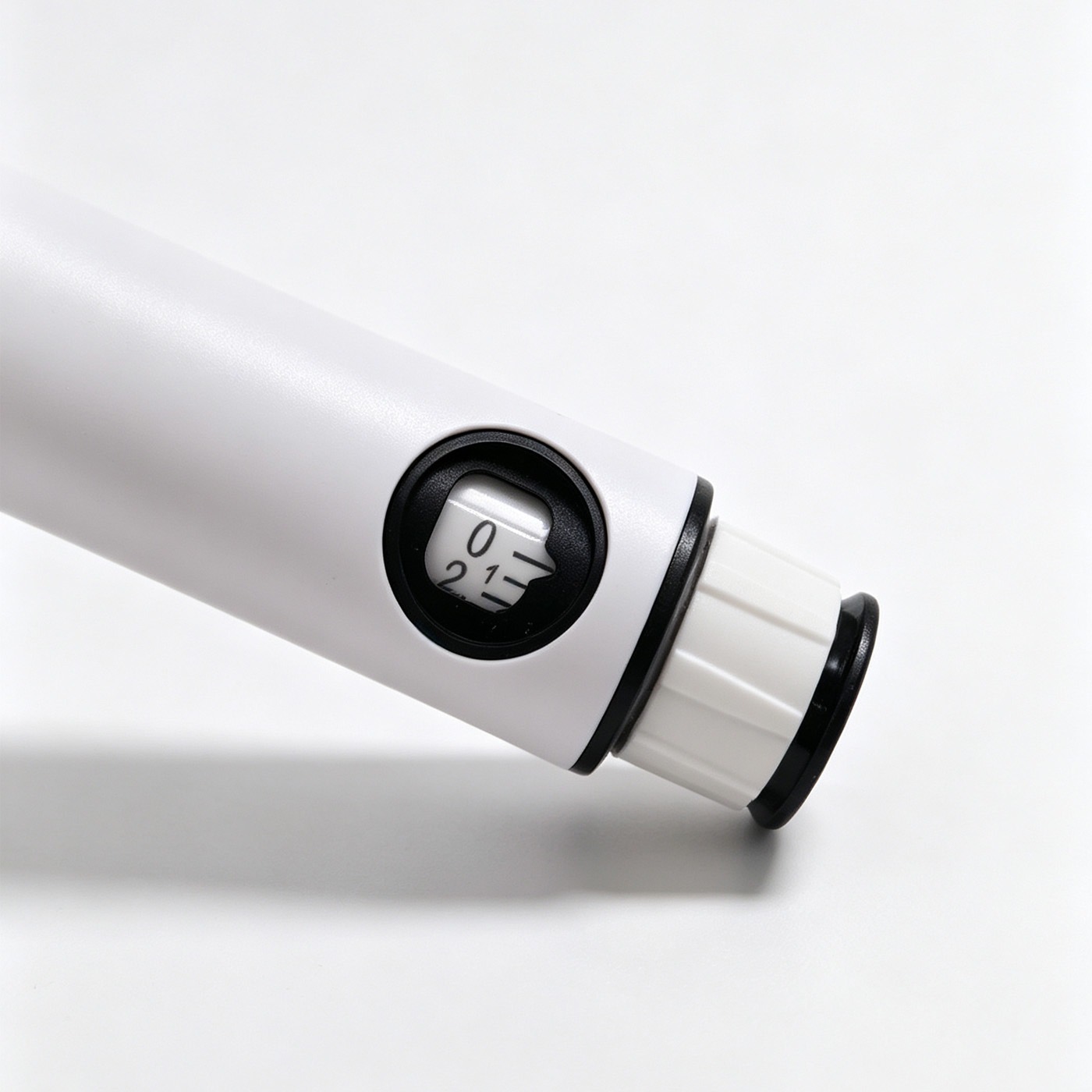Close-up of the white pen body, black indicator window and adjustment dial